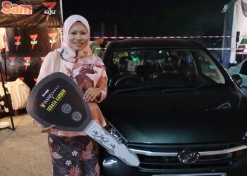 Norshaidatul Akma Borhan bersama Perodua Axia yang dimenangi menerusi cabutan bertuah Glam Bazar Ramadan Klebang. UTUSAN/AMRAN MULUP