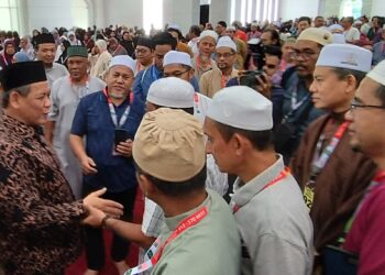 AMINUDDIN Harun (kiri) bersalaman dengan bakal jemaah haji selepas Majlis Perasmian Penutup Kursus Perdana Haji Peringkat Negeri Sembilan bagi musim haji 1445H/2024M di Seremban hari ini.-UTUSAN/NAZARUDIN SHAHARI.