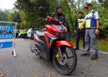 LOKMAN Jamaan (kanan) dalam Operasi Bersepadu Motosikal Hari Raya Aidilfitri di Meru Raya, Ipoh hari ini. - UTUSAN/MUHAMAD NAZREEN SYAH MUSTHAFA