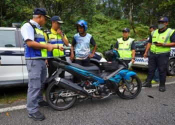 LOKMAN Jamaan (kiri) memeriksa motosikal dalam Operasi Bersepadu di Meru Raya, Ipoh hari ini. - UTUSAN/MUHAMAD NAZREEN SYAH