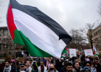 BENDERA Palestin berkibar sewaktu sekumpulan penunjuk perasaan pro-Palestin  berarak di luar kedutaan Israel untuk menyeru gencatan senjata di Gaza di Washington 2 Mac lalu.