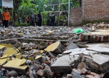 BUPATI Tasikmalaya Ade Sugianto (kanan) meninjau rumah penduduk yang runtuh akibat gempa di Desa Singajaya, Kecamatan Cibalong, Kabupaten Tasikmalaya, Jawa Barat. semalam.-KOMPAS