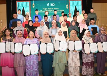 PELAJAR yang menerima sumbangan merakamkan gambar kenangan bersama Mohd. Bakke Salleh (belakang-tiga kiri) dan Masidi Manjun (belakang-tengah) semasa Majlis Ramah Mesra Hari Raya Petronas di kota Kinabalu hari ini