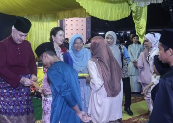 SULTAN Nazrin Muizzuddin Shah dan Tuanku Zara Salim  menyampaikan duit raya kepada kanak-kanak pada Majlis Sambutan Hari Raya Aidilfitri PDRM Kontinjen Perak di Markas Pasukan Simpanan Persekutuan (PSP) Unit 5 di Ipoh semalam. - UTUSAN