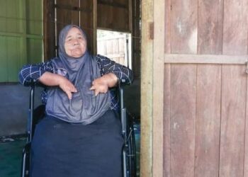 FATIMAH Junoh yang alami kecacatan jari sejak lahir kini bergantung kerusi roda untuk bergerak di rumahnya di Kampung Lerek, Hulu Terengganu. - UTUSAN/NOOR HAYATI MAMAT