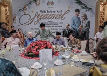 AHMAD Zahid Hamidi meraikan tetamu yang hadir pada Majlis Santunan Kasih Syawal di Sri Satria di Putrajaya. - UTUSAN/FAIZ ALIF ZUBIR