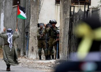 SEORANG penunjuk perasaan mengibarkan bendera kebangsaan Palestin berjalan melepasi tentera Israel, semasa konfrontasi dengan mereka berikutan protes terhadap perampasan tanah Palestin oleh Israel di Tebing Barat yang diduduki, di kampung Kfar Qaddum, pada 9 Jun tahun lalu. -AGENSI