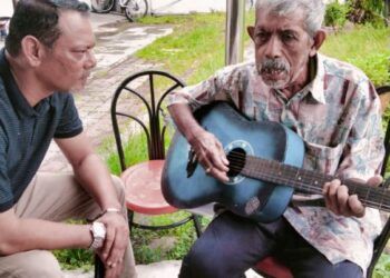 MOHAMED Ali Matab Din atau Ringo (kanan) menunjukkan kemahirannya bermain gitar sambil diperhatikan Pengerusi 99 Kesan, Muhd.Ali Zakariah semasa pertubuhan itu melawatnya di Masjid Raudhatul Mukminin Jalan Kapar, Klang, Selangor, semalam - MINGGUAN/ABDUL RAZAK IDRIS