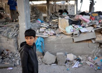 SEORANG kanak-kanak Palestin berdiri di hadapan bangunan yang musnah akibat pengeboman Israel di Rafah di selatan Gaza.-AFP
