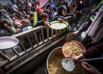 RATUSAN kanak-kanak Palestin beratur untuk menerima makanan di sebuah sekolah kerajaan di Rafah di selatan Semenanjung Gaza.-AFP