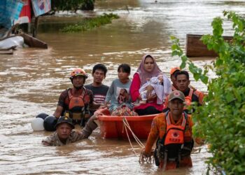 ANGGOTA pasukan SAR membantu menyelamatkan penduduk yang terkandas di daerah Luwu di Sulawesi Selatan.-AGENSI