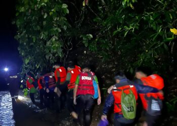 PASUKAN bomba menyelamatkan pendaki yang terkandas akibat kejadian kepala air di Lembah Mak Sina River Trekking, Pantai Makuau, Lahad Datu, Sabah, malam tadi. - IHSAN BOMBA