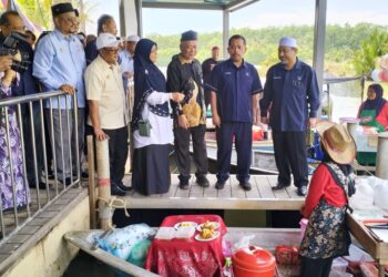 MOHD. Nassuruddin Daud (kanan) beramah mesra dengan peniaga selepas perasmian Pasar Terapung Pulau Suri, Tumpat, Kelantan, hari ini. - UTUSAN/ROHANA ISMAIL