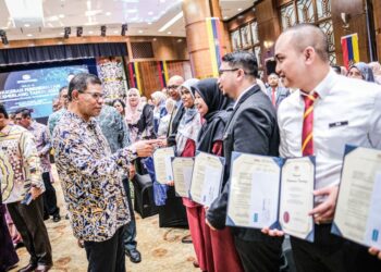 SAIFUDDIN Nasution Ismail beramah mesra bersama penerima anugerah selepas Majlis Anugerah Perkhidmatan Cemerlang (APC) Jabatan Pendaftaran Negara (JPN) di Jabatan Pendaftaran Negara, Putrajaya di sini, semalam. - UTUSAN/FAIZ ALIF ZUBIR