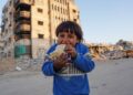 SEORANG kanak-kanak gembira dapat menjamah roti di Khan Younis, selatan Gaza. -AFP