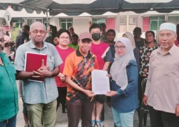 MOHAMAD Nazri Saidin (empat dari kiri) menyerahkan tuntutan penduduk semasa sesi dialog berhubung isu banjir di Taman Serai Perdana, Bagan Serai, Perak, semalam. - UTUSAN/WAT KAMAL ABAS