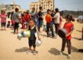 KANAK-KANAK Palestin yang dipindahkan beratur untuk menerima makanan di Rafah, di selatan Gaza, pada 19 Mei lalu. -AFP