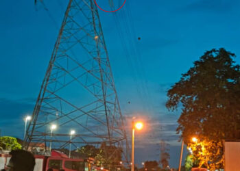 SEORANG lelaki (dalam bulatan merah) memanjat pencawang elektrik di Kampung Muhibbah di Tanah Merah, Jitra malam ini.