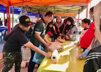 ORANG ramai beratur membeli telur ayam gred B dalam program Jualan Agro Madani di Pasar Nelayan Pulau Gajah, Kota Bharu, Kelantan, hari ini. - UTUSAN/ROSLIZA MOHAMED