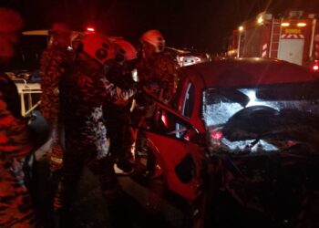 ANGGOTA bomba mengeluarkan mangsa dalam kemalangan dua kereta di WCE, di Changkat Jering, Taiping semalam. - UTUSAN/JBPM PERAK