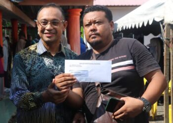 HARIS Salleh Hamzah (kiri) menyampaikan Notis 5A Skim Tanah Rakyat di Felda Kota Gelanggi 1, Jerantut, hari ini. - UTUSAN/SALEHUDIN MAT RASAD