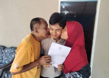 BASURI Sarbun dan Sanah Sirin mencium pipi Muhammad Faris selepas memperolehi  keputusan cemerlang SPM  2023 di rumahnya di Kampung Parit Salleh, Benut, di Pontian. - UTUSAN/MUHAMMAD ZIKRI