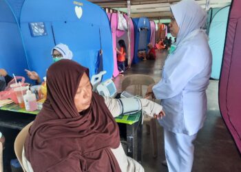 NIK Suria Jusoh menjalani pemeriksaan kesihatan ketika berada di PPS Sekolah Agama Ihsaniah Jangkang, Karangan di Kulim.