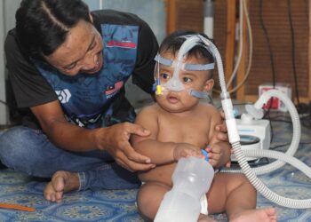 MOHD Azlan Ishak bersama anaknya, Mohd. Aariz Zafran yang menghidap paru-paru kronik, gerd dan saiz limpa yang besar memerlukan alat bantuan pernafasan 24 jam ketika ditemui di Kuala Kedah, Alor Setar.
