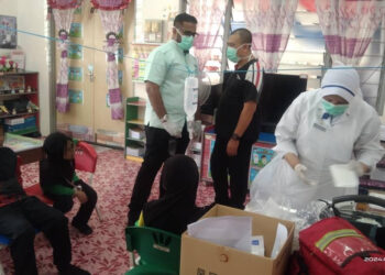 PETUGAS kesihatan sedang memberikan rawatan kepada murid-murid yang keracunan makanan di SK Bandar Puteri Jaya, Sungai Petani.