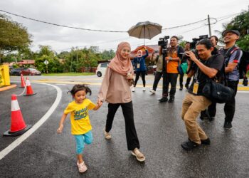 Maryam Yusof bergegas masuk ke pusat mengundi di saat akhir pada Pilhan Raya Kecil dun Kuala Kubu Baharu, di SMK Kuala Kubu Baharu, di sini hari ini. Foto: SHIDDIEQIIN ZON