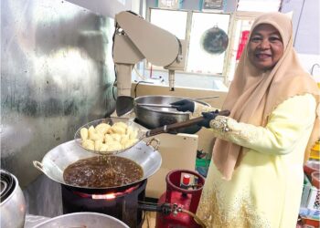 MAJIDA Ibrahim bersama karipap yang diusahakannya di Bukit Mertajam, Pulau Pinang selepas mendapat pembiayaan dan mengikuti kursus yang disediakan oleh Amanah Ikhtiar Malaysia (AIM).