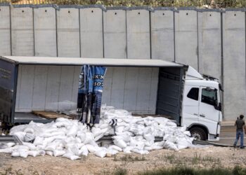 Pemandu lori merakam keadaan bahan makanan untuk misi kemanusiaan di Gaza yang dirosakkan oleh penunjuk perasaan Israel semalam. -AFP