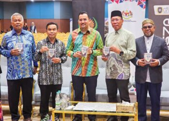 ASyRAF Wajdi Dusuki (tengah) menunjukkan buku poket Hadis 40 Imam Al-Nawawi dalam majlis pelancaran buku itu di UniSZA, 
Kuala Nerus, Terengganu semalam.