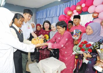TIGA pelajar menyampaikan kek kepada Wong Cheui Keen sempena Sambutan Hari Guru peringkat sekolah di SMK Impian Emas, Johor Bahru semalam. – UTUSAN/RAJA JAAFAR ALI