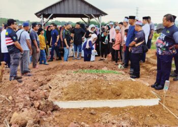 ANAK sulung arwah, Nur Lelfa Syahirah Md. Rizal menyiram air mawar ke atas pusara ayahnya di Tanah Perkuburan Islam Seksyen 21, Shah Alam, semalam. – utusan/ MOHAMAD NAUFAL MOHAMAD IDRIS
