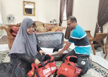 NOORAZURA Kadir dan Mohd. Aliuddin Osman mengemas barangan  yang akan dibawa ke Mekah  di rumahnya di Kampung Parit Jelotong Darat, Ayer Baloi, Pontian, Johor. – UTUSAN/MUHAMMAD ZIKRI