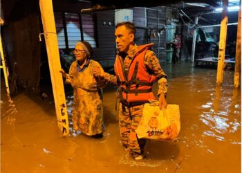 ANGGOTA  bomba membawa mangsa banjir di Kampung Batu 9, Jalan Changkat Jong di Hilir Perak ke kawasan selamat selepas rumah mereka dinaiki air, semalam. - UTUSAN/IHSAN JBPM