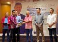 BUNG Moktar Radin (tiga kanan) menyampaikan watikah pelantikan pengerusi JKDM kepada salah seorang penerima di Wisma UMNO Sabah di Kota Kinabalu, hari ini