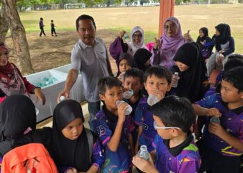SEBAHAGIAN daripada murid yang menerima air mineral secara percuma SK Kompleks Gong Badak, Kuala Nerus, hari ini. - UTUSAN/KAMALIZA KAMARUDDIN