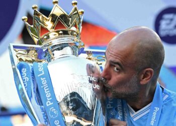 PEP Guardiola mengucup trofi Liga Perdana Inggeris selepas aksi terakhir menentang West Ham di Stadium Etihad, semalam. - AFP