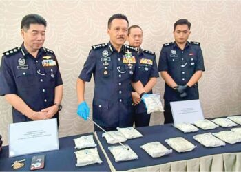 MOHD. YUSRI Hassan Basri (tengah) menunjukkan dadah yang dirampas dalam serbuan di sebuah rumah 
di Langkap Isnin lalu pada sidang akhbar di IPK Perak di Ipoh. –  UTUSAN