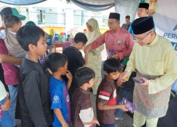 SAIFUDDIN Abdullah (kanan) menyampaikan sumbangan duit raya kepada kanak-kanak yang hadir rumah terbuka PN Parlimen Indera Mahkota di Kampung Padang di Kuantan, Pahang.