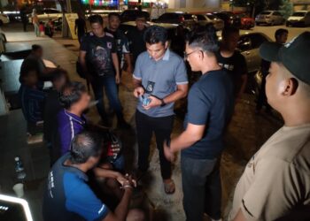 ANGGOTA penguat kuasa menyoal siasat ulat parkir yang ditahan di kawasan parkir MBMB di hadapan Masjid Kampung Hulu, Banda Hilir, Melaka. - UTUSAN/AMRAN MULUP
