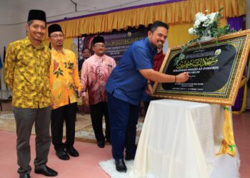 MANNDZRI Nasib (kanan) menurunkan tandatangan sebagai gimik perasmian
Masjid As-Syakirin di Sekolah Menengah Kebangsaan Agama Melor, Kota Bharu, Kelantan hari ini-UTUSAN/KAMARUL BISMI KAMARUZAMAN.