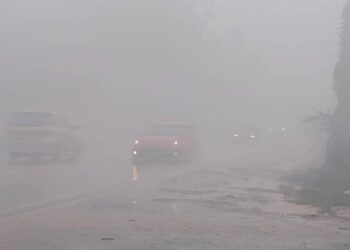 KEADAAN jalan diselubungi asap tebal 
dari pusat pelupusan sampah ketika hujan di Sungai Ikan, Kuala Nerus, hari ini. - UTUSAN/KAMALIZA KAMARUDDIN