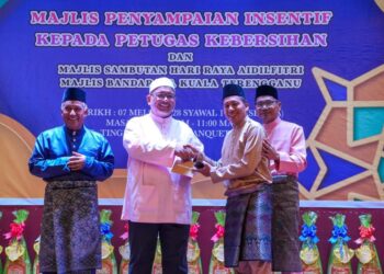 WAN SUKAIRI  Wan Abdullah (dua dari kiri) menyampaikan insentif kepada salah seorang petugas kebersihan MBKT sempena
sambutan Aidilfitri kakitangan MBKT di Kuala Terengganu, semalam.  - UTUSAN/KAMALIZA KAMARUDDIN