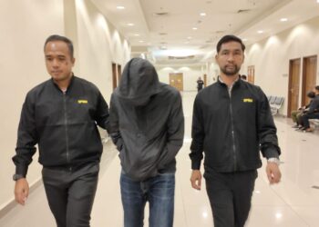 TERTUDUH (tengah) mengaku tidak bersalah atas pertuduhan menerima suapan bernilai RM1,830 ketika dihadapkan ke Mahkamah Sesyen Kuantan di Kuantan, Pahang.