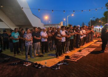 PENYOKONG TFC mengadakan solat hajat dan doa selamat memohon kesembuhan buat Akhyar Rashid dan Faisal Abdul Halim sebelum aksi menentang Perak di perkarangan Stadium Sultan Mizan Zainal Abidin, Kuala Nerus, malam tadi. - UTUSAN/PUQTRA HAIRRY ROSLI