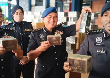 M. KUMAR {kanan) menunjukkan rokok yang dirampas dalam sidang akhbar di Markas Pasukan Polis Marin Wilayah 2, Johor Bahru.