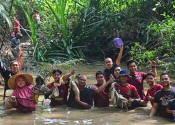 PENDUDUK menunjukkan sebahavian ikan yang ditangkap pada program 'Nimber' Ikan Sungai di Lubuk Pengkalan Setar, Kampung Sungai Ikan di sini,  semalam. - UTUSAN/PUQTRA HAIRRY ROSLI